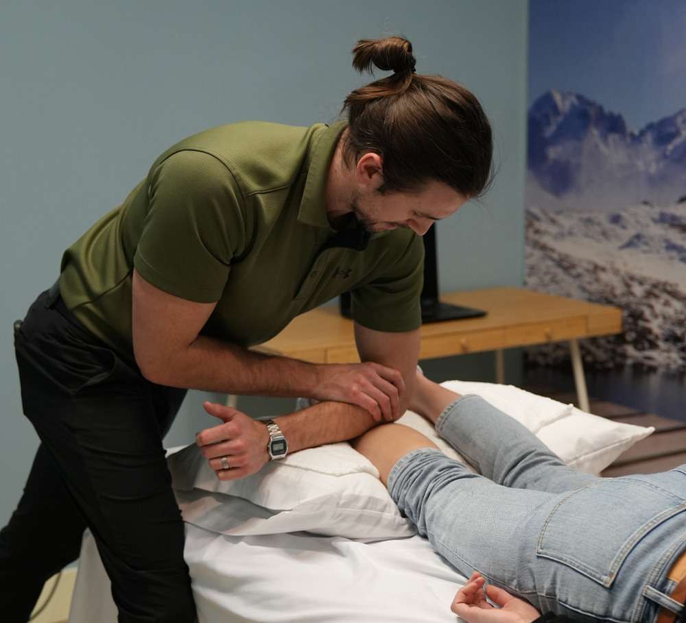 Home 3 john thornton physiotherapist burlington on conducting manual therapy on patient calf muscles 1